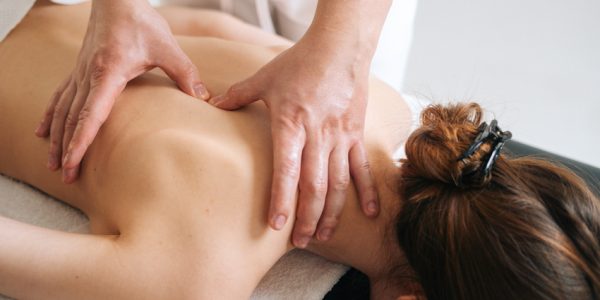 Male,Masseur,Massaging,Back,And,Shoulder,Blades,Of,Young,Woman